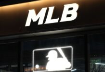 How Minor League Life Shapes MLB Stars Close up Major League Baseball (MLB) sign at night.
