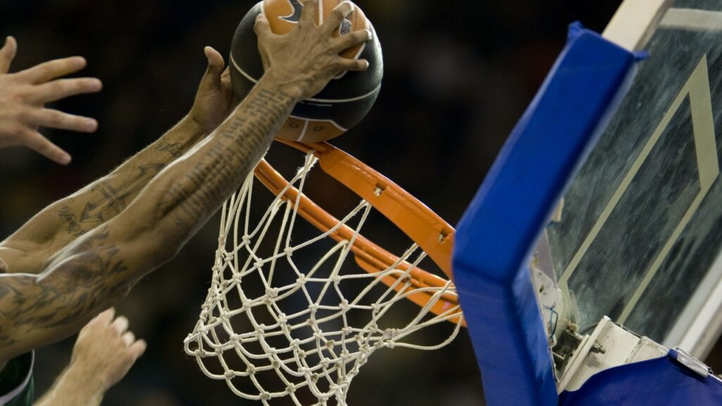 Player putting basketball in the net. 