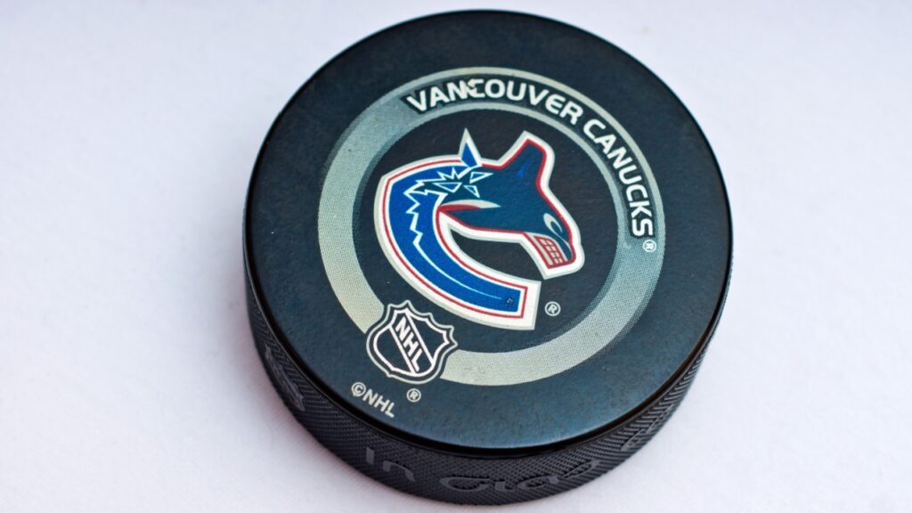 Official Vancouver Canucks game puck on the ice. 