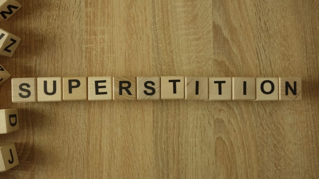 Shutterstock Superstition Myths 1356000305 - Gameday Chatter Superstition word from wooden blocks on desk.