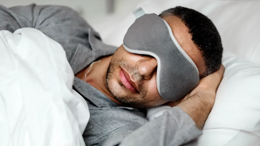 A man sleeping with a sleeping mask.