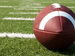 Closeup of American football on field.