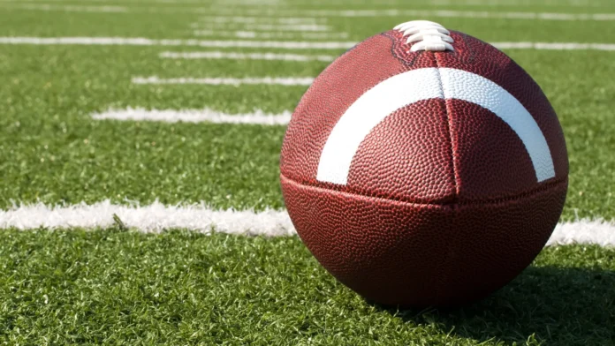 Closeup of American football on field.
