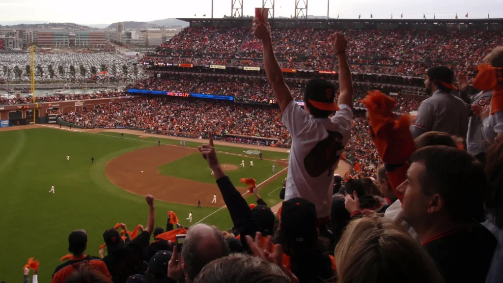 Giants fans throughout the ballpark cheer as they raise hands