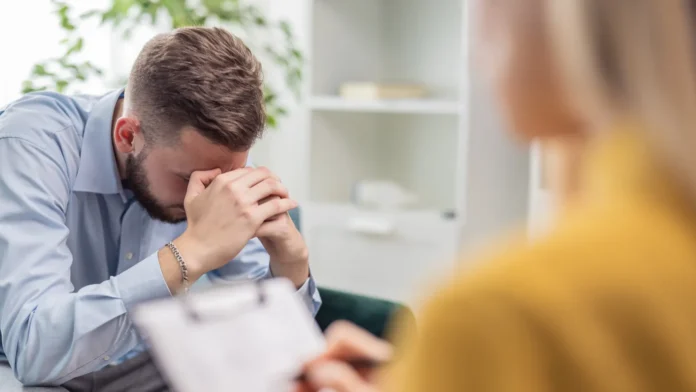 Psychologist making notes during a therapy session.
