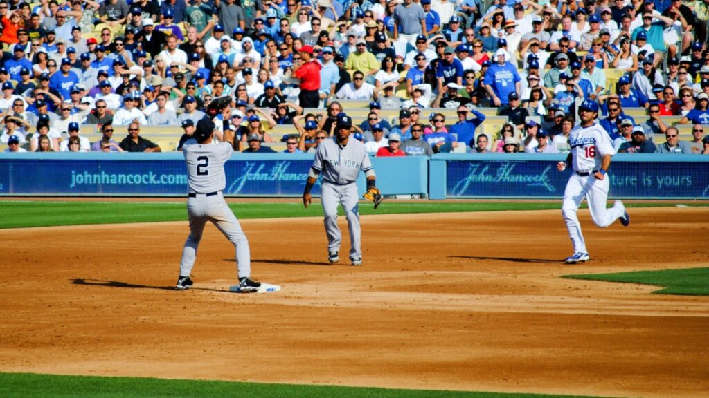 New York Yankees second baseman Robinson Cano and shortstop Derek Jeter turn a double play ahead of Dodger outfielder Andre Ethier