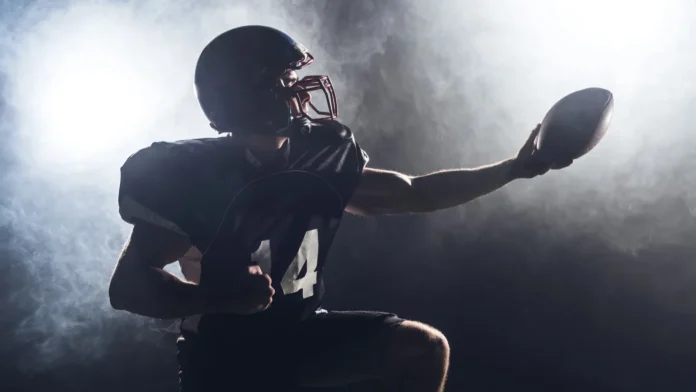 American football player holding football.