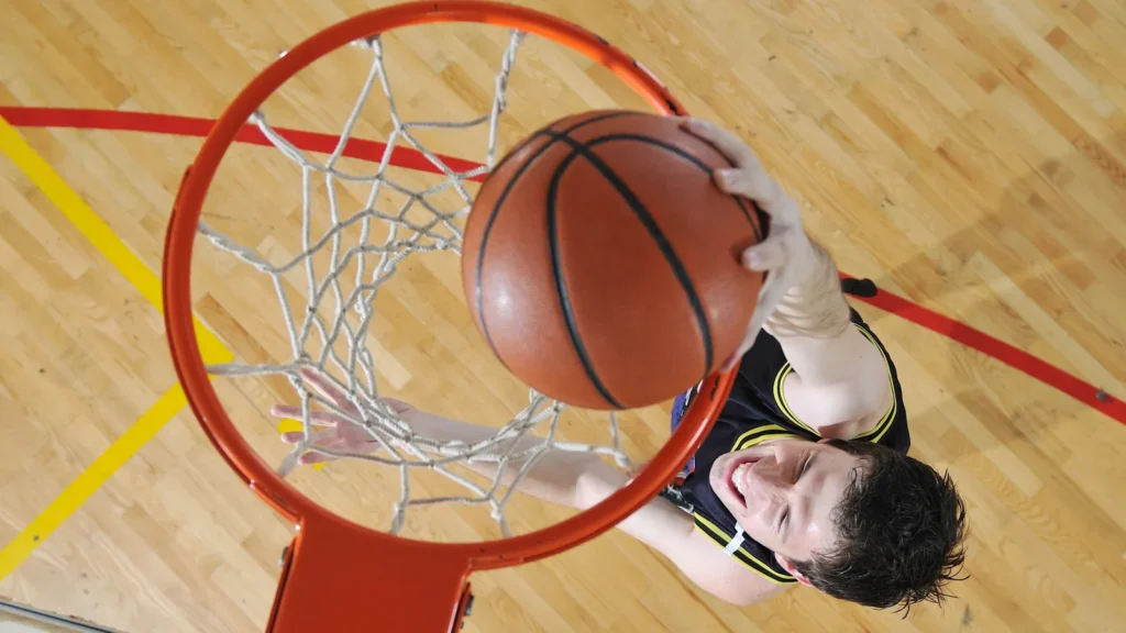 A basketball player, viewed from above, dunks a basketball into a hoop.