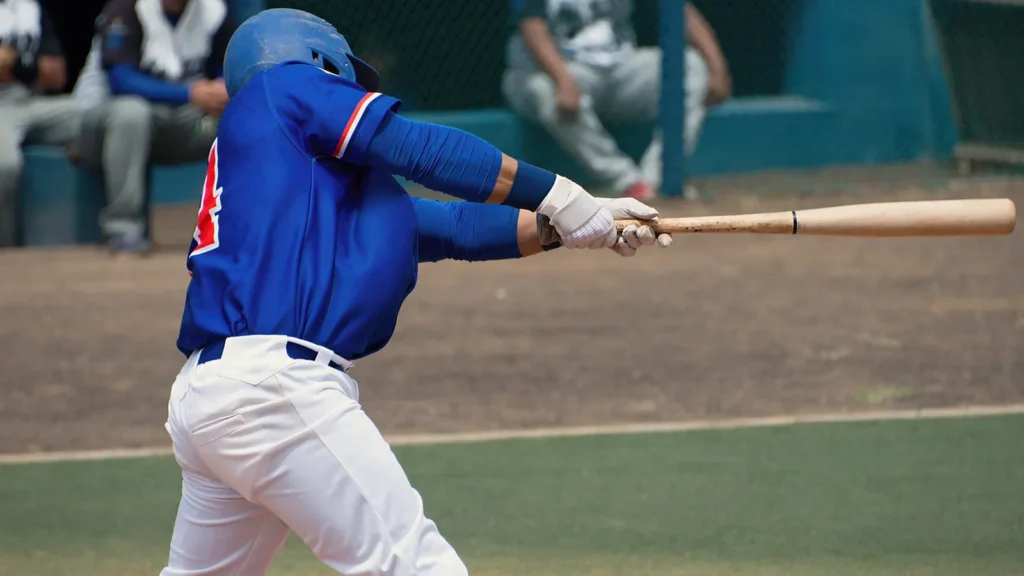 Men's league player in blue shirt swinging bat.