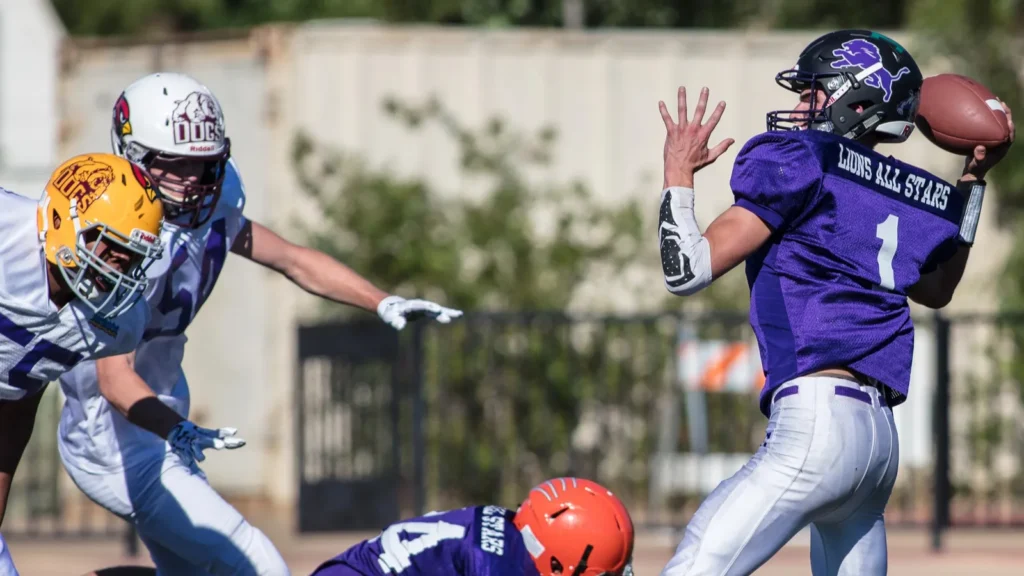 A football player in coverage as a receiver catches a pass during a game.