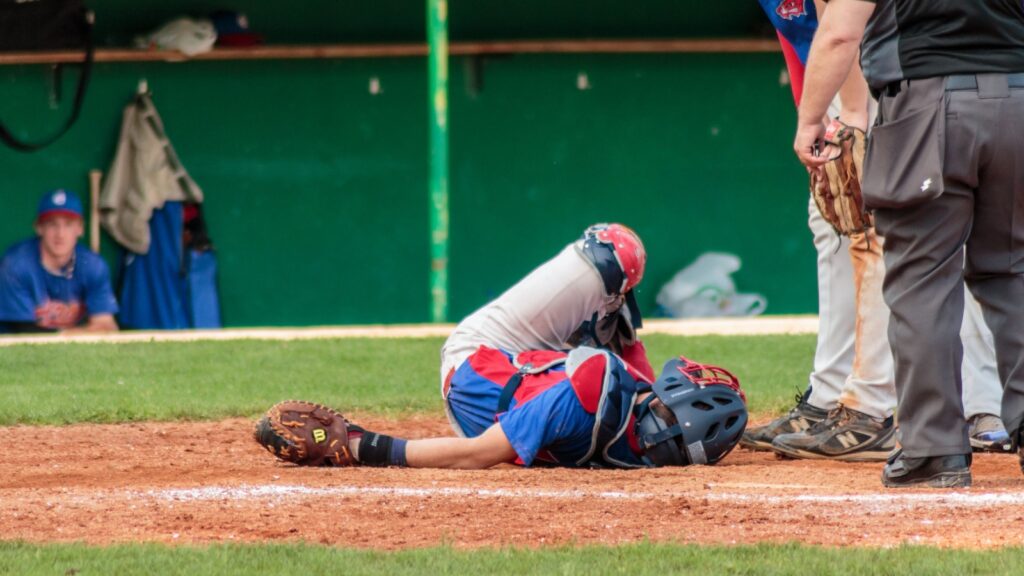 An injured baseball player lying on the field.