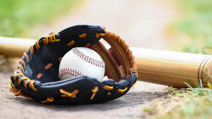 Baseball glove, ball, and bat on the field.