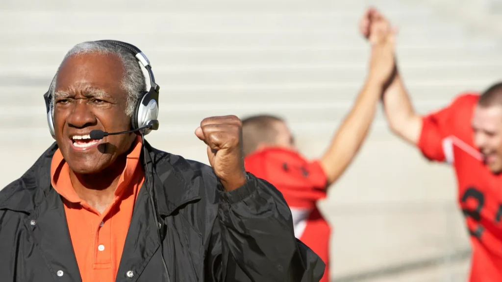 NFL defensive coordinator with headset during game.