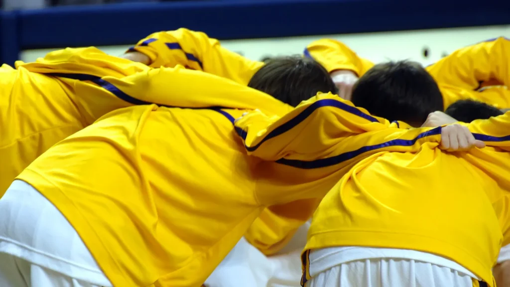 The basketball team huddles together before the game starts.