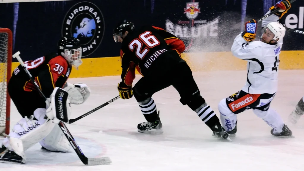 jokerit helsinki vs sc bern - Gameday Chatter Ice hockey forward drives to goal with puck against defenders.