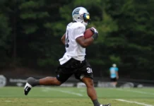 The hidden role of practice squads in sustaining NFL success A football player sprinting with the ball during a game.