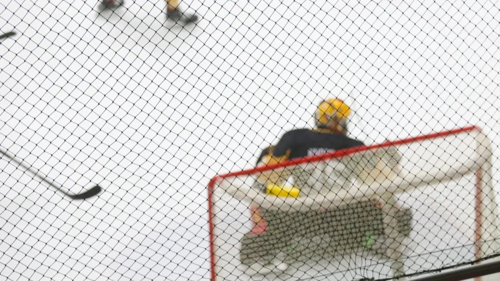 Top view of a hockey goalie standing in the goal.