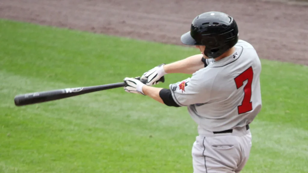 A baseball player swings a bat during game action on the field.
