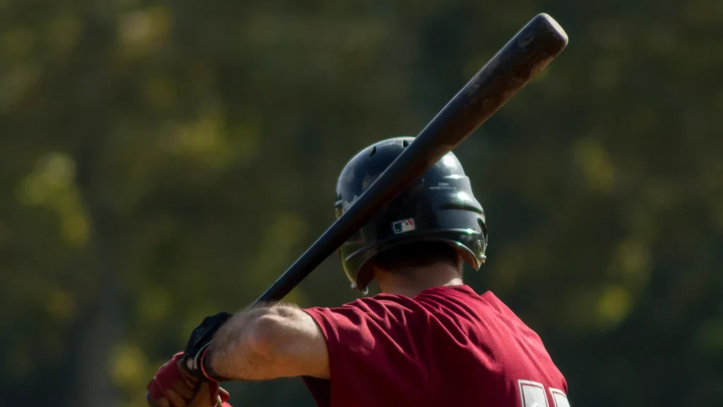 A baseball player wearing a helmet holding a bat over his shoulder, preparing to swing.