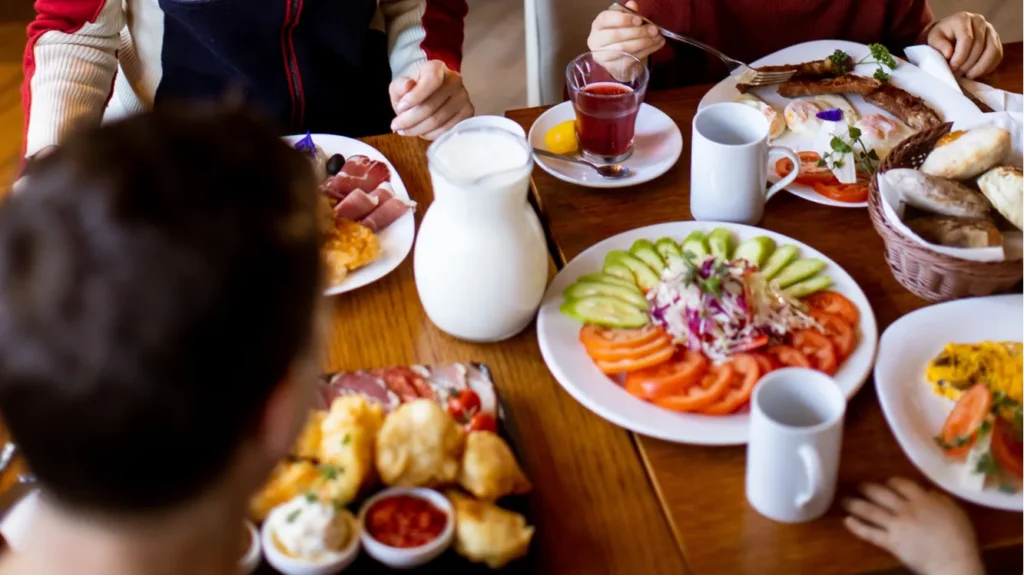 a family gathers around a table to share breakfast in
