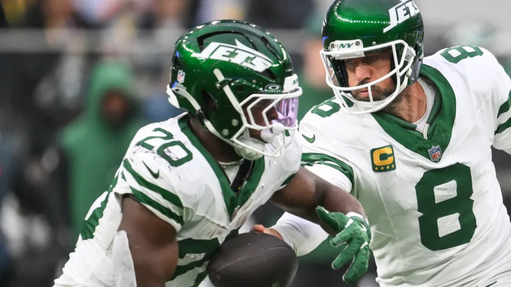 aaron rodgers of the new york jetshands the ball off