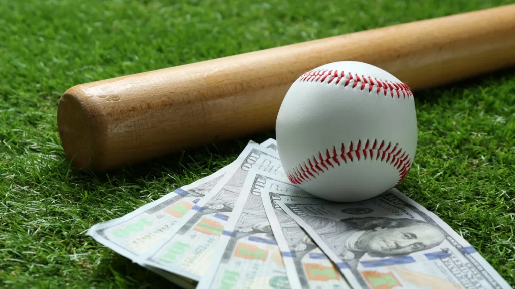 Baseball bat, baseball, and dollar notes on grass outdoors.