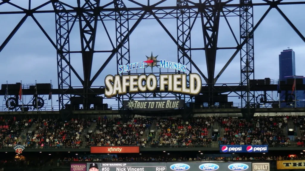cardinals players stands in the outfield with fans in bleachers