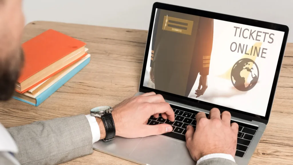 A person using a laptop to book tickets through an online reservation system