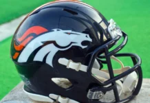 Denver Broncos reveal full coaching staff for the 2026 season Denver Broncos' helmet placed on a wooden table.