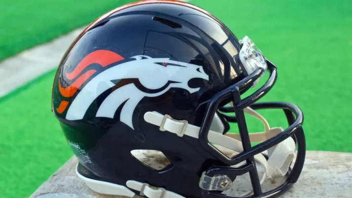 denver broncos helmet Denver Broncos' helmet placed on a wooden table.