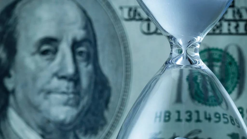 dollar bill with egg timer or hourglass with running sand