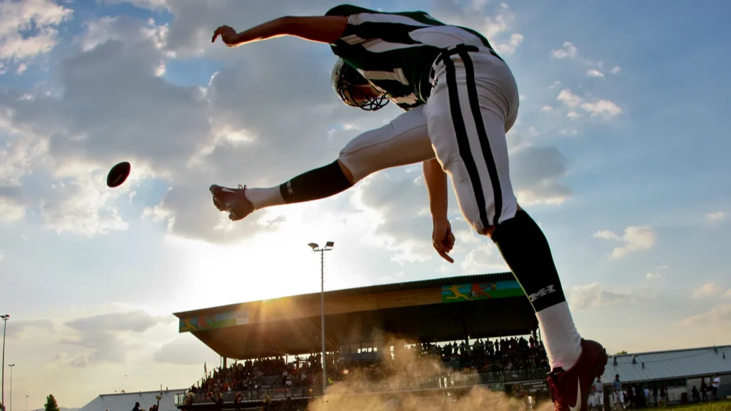 A football player kicking the football.