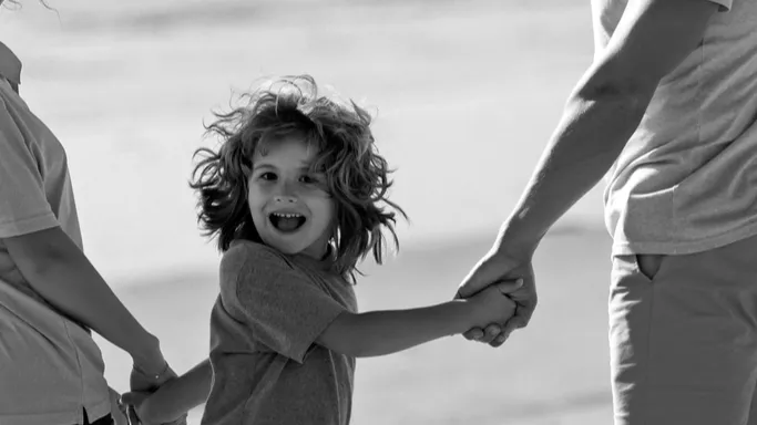 family walk along sea beach happy parents with child playing