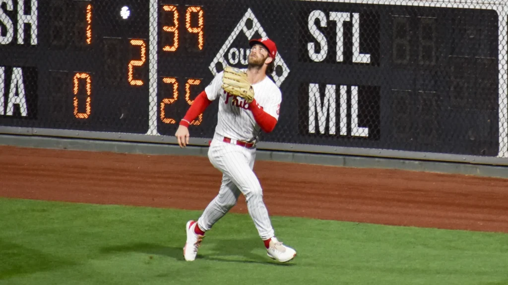 Bryce Harper outfielder, trying to catch a flying ball in the outfield during a game.
