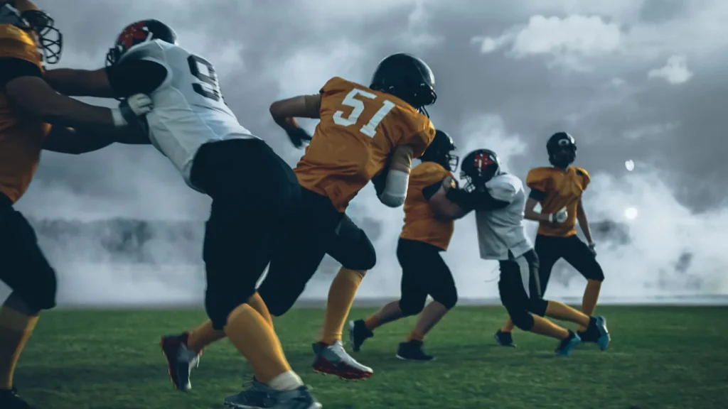 two professional american football teams stand opposite each other ready