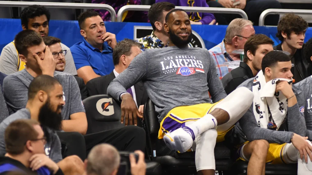 LeBron James sitting on the Los Angeles Lakers bench during an NBA game.