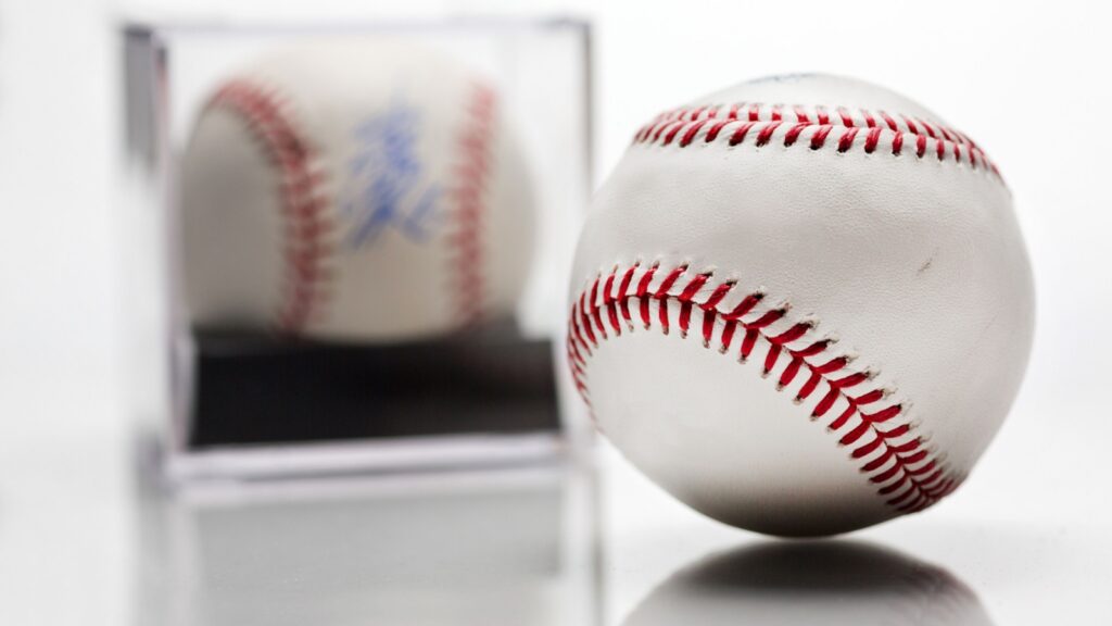 Signed baseball in a display case next to a regular baseball