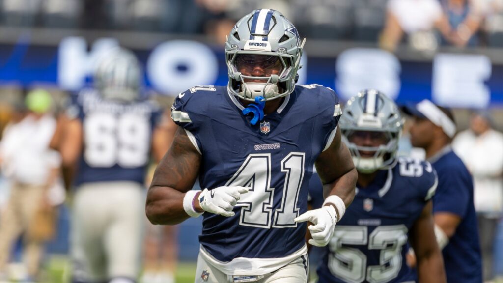 Donovan Ezeiruaku running on the game field before a football match.