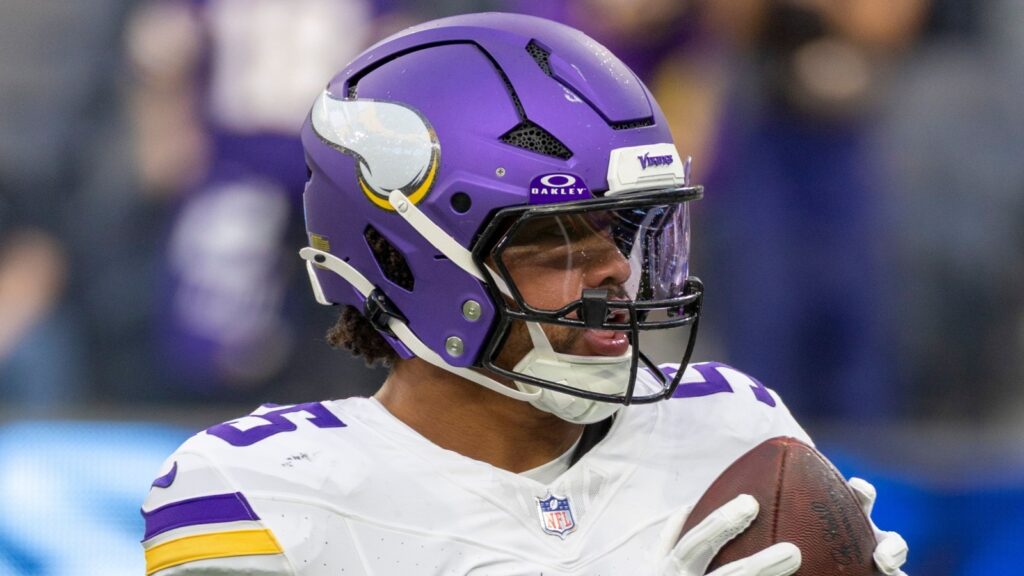 Minnesota Vikings linebacker Eric Wilson holding a football during an NFL game.