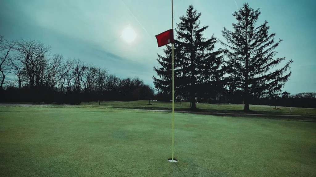 a red golf flag in a field under the sunlight
