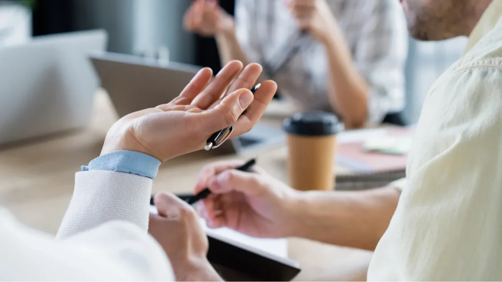 African american businesswoman with pen working near blurred colleagues