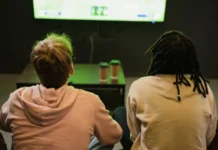 USA-France FIBA Women’s World Cup final draws 1.2 million viewers in 2026 Back view of interracial friends watching sports match.