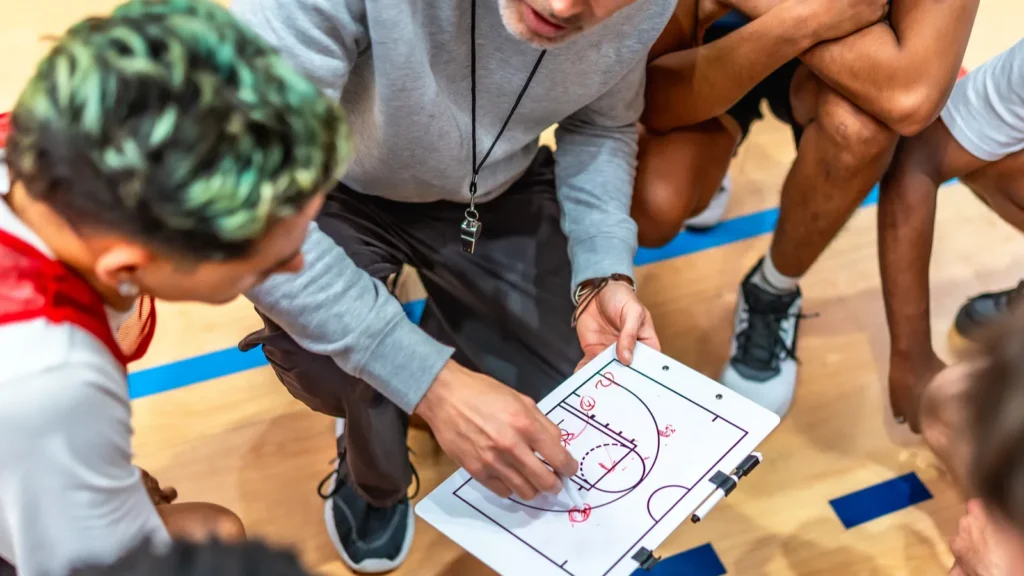 A basketball coach discussing game strategy with his team.