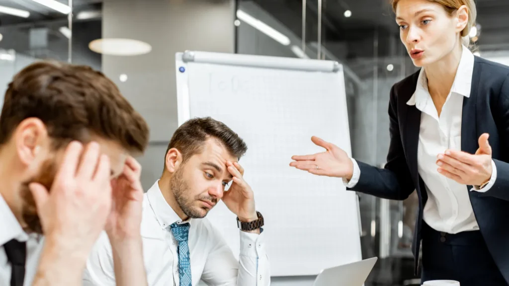 Boss quarreling at employees during a conference