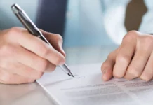 Danny Coulombe opens up about his last-minute deal with the Red Sox A white person signing business contract.