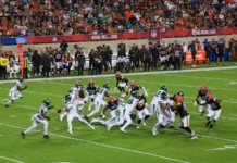 Myles Garrett trade buzz grows after Browns adjust contract structure An American football game between the Cleveland Browns and the Jets in progress at a packed stadium at night.