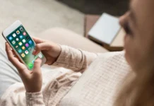 cropped shot of woman on couch using a smartphone