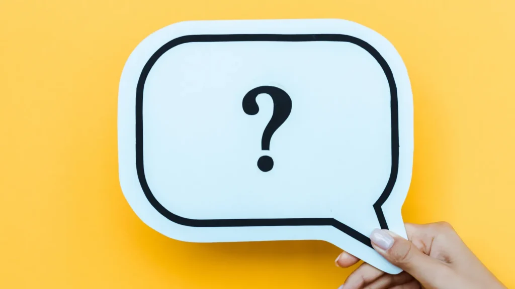 cropped view of woman holding speech bubble with question mark on orange