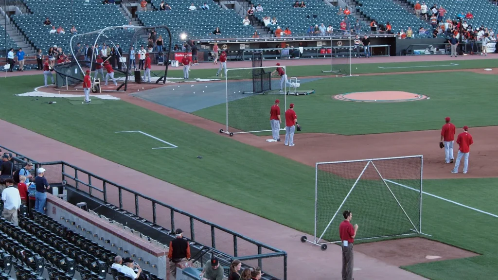 Diamondback Bullpen coach throws pitch to hitter during batting