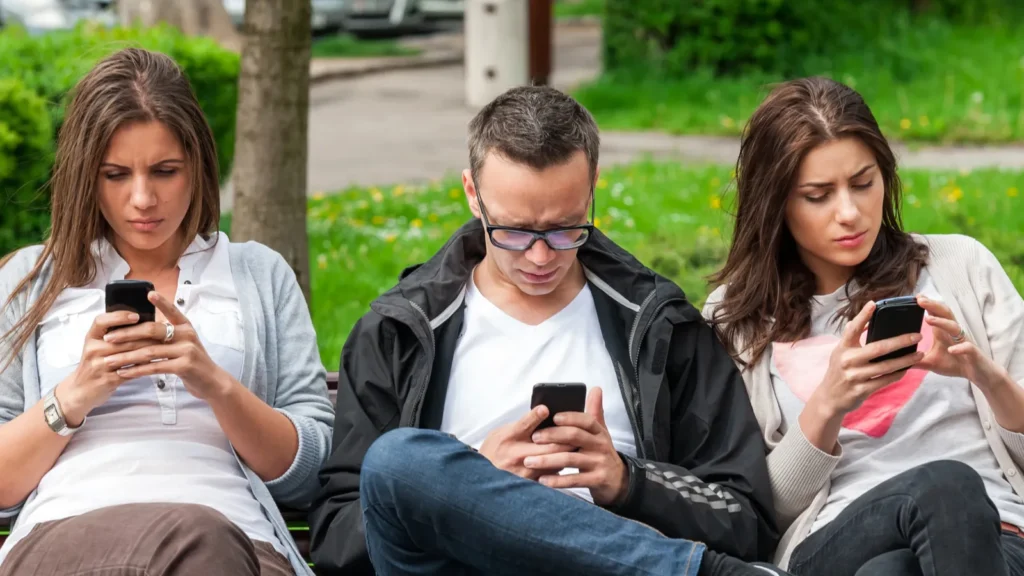 Focused group of friends looking on their phones and not socializing